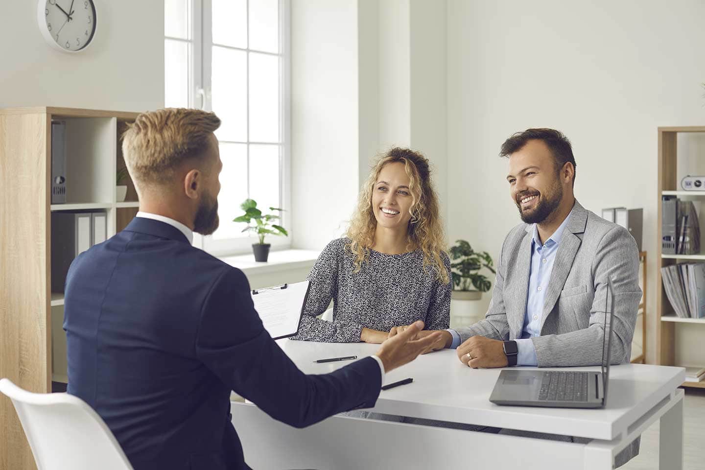 Ein junges Pärchen sitzt im Büro eines Immobilienberaters und lässt sich über Datenschutz aufklären.