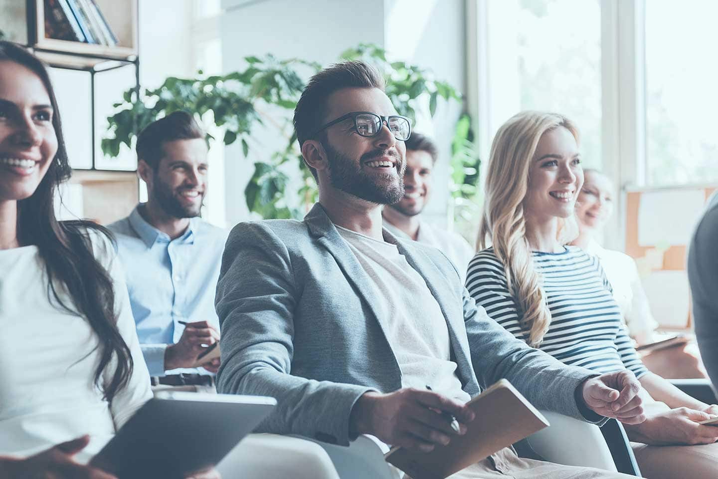 Junges Team sitzt in Seminar zum Thema Mitarbeiterschulung im Datenschutz.
